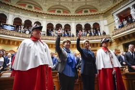 Deux femmes prêtent serment devant le Parlement suisse.
