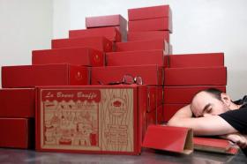 连轴加班制作包含6种瑞士香肠的“中秋限量超值礼盒”，Kaeser累到直接靠在一摞礼盒上睡着。