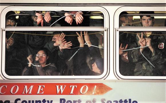 رجال ونساء، متظاهرون معتقلون في حافلة وينظرون من النافذة