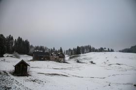 Casa isolada no meio de um campo nevado