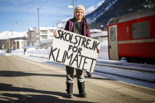Greta Thurnberg a su llegada a Davos, con un cartel en la mano.