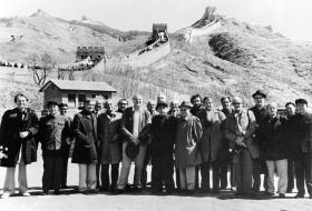 مجموعة من الرجال يقفون أمام سور الصين العظيم