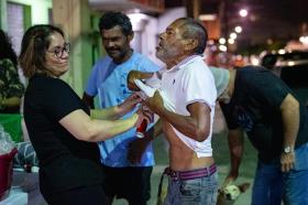 una donna spruzza del deodorante sul torso di un uomo