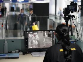 Una mujer observa la pantalla de un monitor en un aeropuerto.