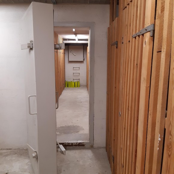Vista de um abrigo com porta de concreto grossa e saída de emergência