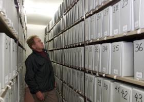 Un hombre observa estantes de archivos
