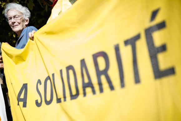 Una mujer con una banderola y la inscrpción: Solidaridad