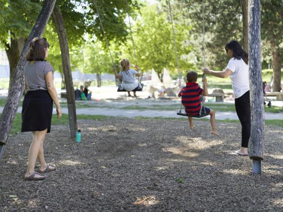 أطفال يلعبون مع أبائهم في حديقة عامة