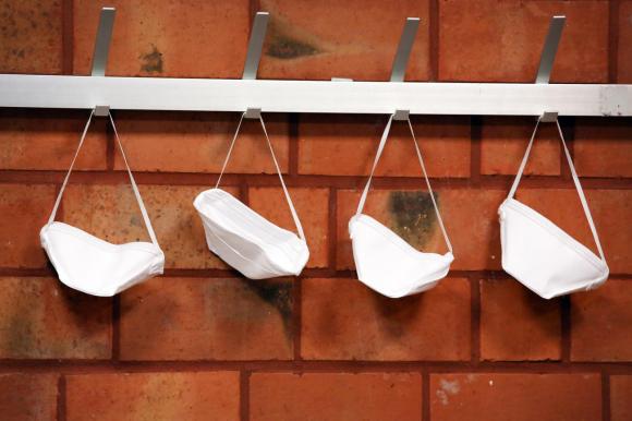 Schutzmasken hangen an Garderobe.