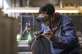 Worker in goggles operates a machine