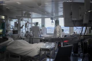 Cuatro miembros del personal médico atienden a un enfermo en UCI