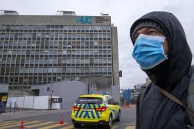 Man arriving at Geneva University Hospital wearing a mask