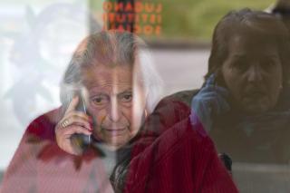 dos mujeres hablan por teléfono y a través de una ventana