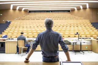 Un hombre de espaldas frente a un auditorio vacío