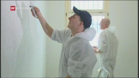 two men paint a wall