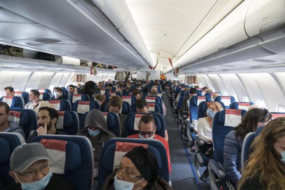 Personas con mascarillas protectoras a bordo de un avión