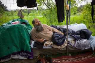 Un homme dort par terre dans un parc