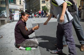 Une femme mendie assise dans la rue