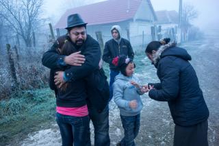 Une famille s enlace devant une maison