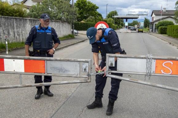 Swiss soldiers inform a cyclist that the Swiss-French border near Thonex, Geneva, is closed