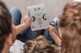 Parents and their child look at an e-book.
