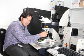 Jeremy Herren arbeitet mit dem Mikroskop