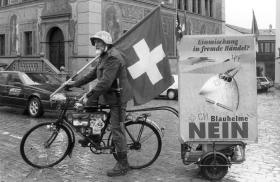 Homem de bicicleta com uma bandeira suíça