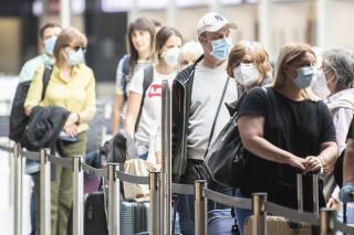 2020年5月28日，苏黎世机场，戴着防护口罩的旅客们在值机柜台排队等候。