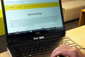 laptop sul cui schermo appare una pagina del sito della Posta Svizzera in cui è descritto l e-voting