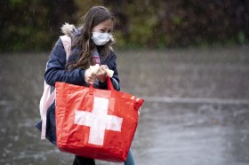 فتاة تحمل كيسا رسم عليه علم سويسرا
