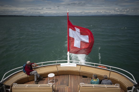 Un hombre en embarcación con bandera suiza