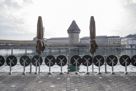 Mesas y sombrillas cerradas en un restaurant a la orilla del lago, en Lucerna.
