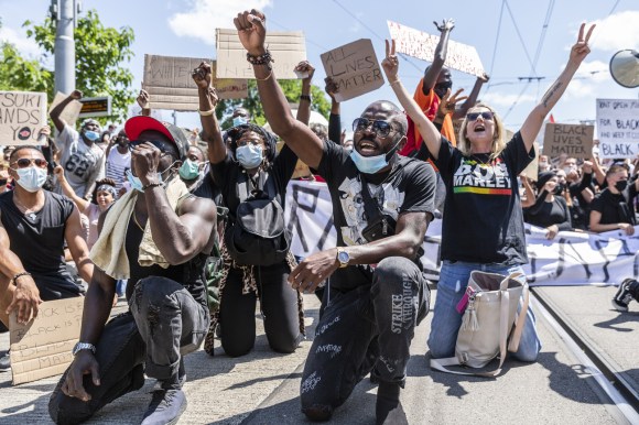 Manifestantes, algunos con una rodilla en el suelo, protestan contra el racismo