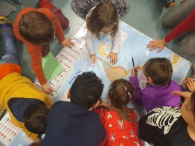 Crianças debruçadas sobre um mapa