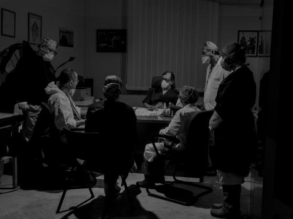 黑白照片呈现的一群坐着讨论的医护人员