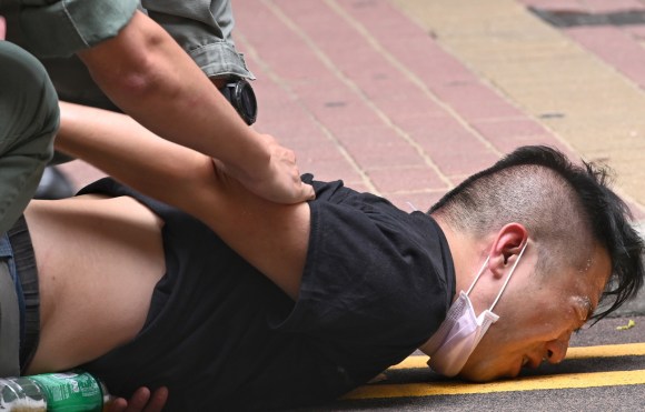 在周三香港发生的反对新《香港国安法》集会上，警察用胡椒喷雾剂制伏一名抗议者后将其拘捕。