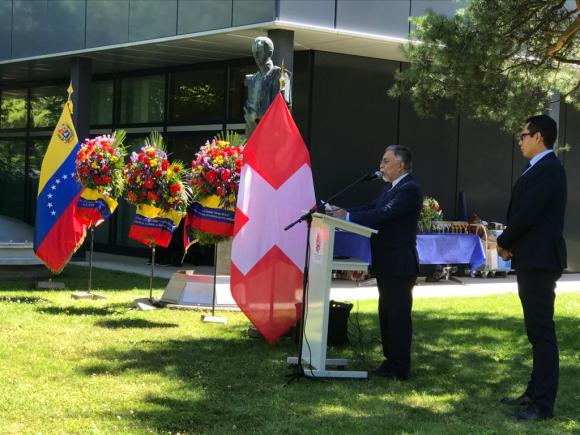 El embajador venezolano en un podio junto a las banderas de Suiza y Venezuela