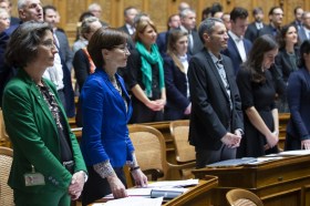 رجال ونساء وقوفا داخل قاعة جلسات البرلمان السويسري