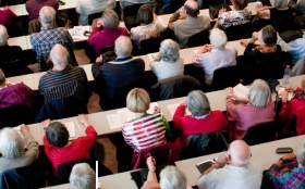 Personas mayores asisten a una conferencia.