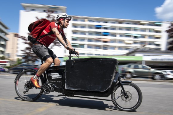 2020年4月25日，瑞士洛桑市，velocite快递公司“骑手小哥”Jean-Sebastien Luy面对新冠病毒疫情暴发的紧急状态下，依然骑着货运自行车为居家隔离的市民送去食物。 (KEYSTONE/Laurent Gillieron)