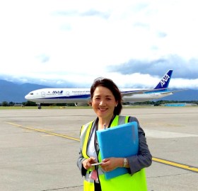 Femme souriante posant devant un avion japonais