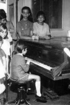 O maestro quando menino sentado ao piano