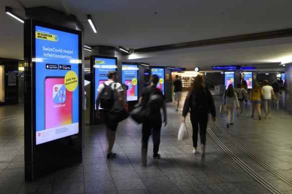 Werbeanzeige im Bahnhof Bern für Covid-App