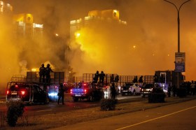 سيارات ورجال شرطة ودخان كثيف أثناء مواجهات مه المتظاهرين