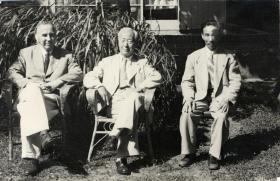 صورة بالأبيض والأسود لثلاثة رجال جالسين فوق كراسي