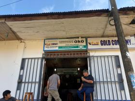رجال يقفون أمام متجر لتجارة الذهب