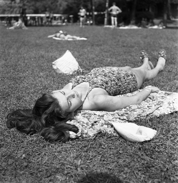 Mulher tomando banho de sol no gramado