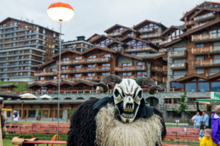 frightening animal mask in front of chalets