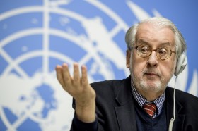 رجل يتحدث وفي الخلفية علم الأمم المتحدة