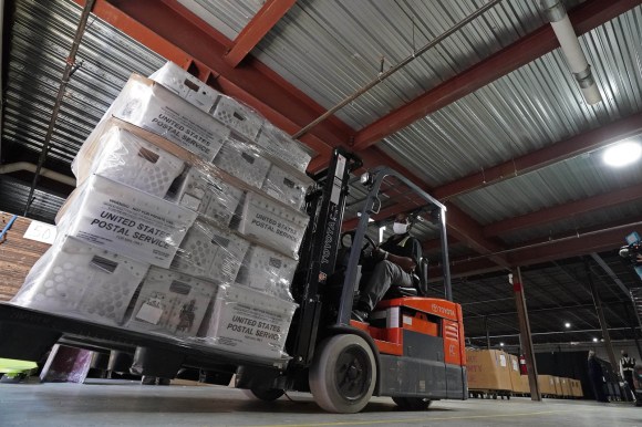 Pacchi di buste elettorali pronti per l invio postale.